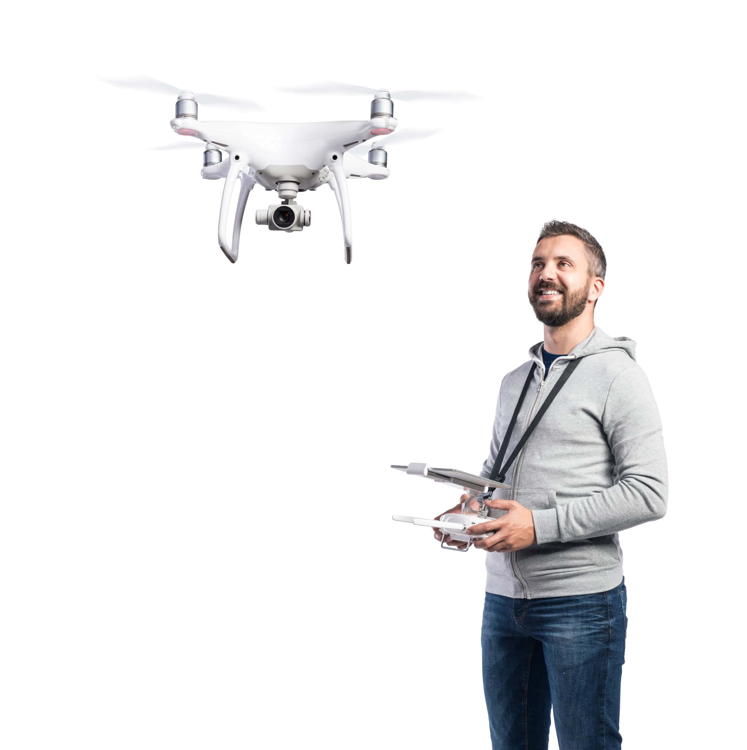 Man with remote control and flying drone with camera. Studio shot on white background, isolated.
